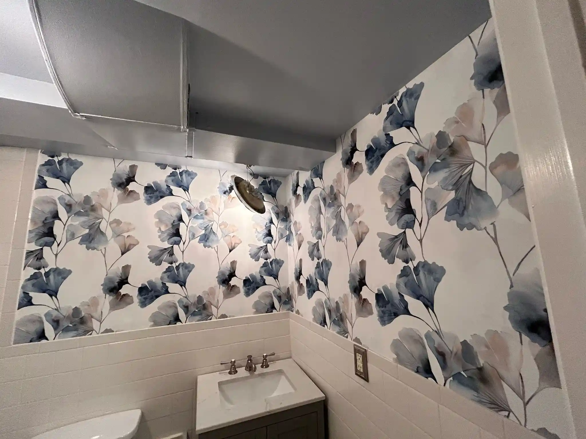 Large botanical wallpaper pattern extending around a compact room.